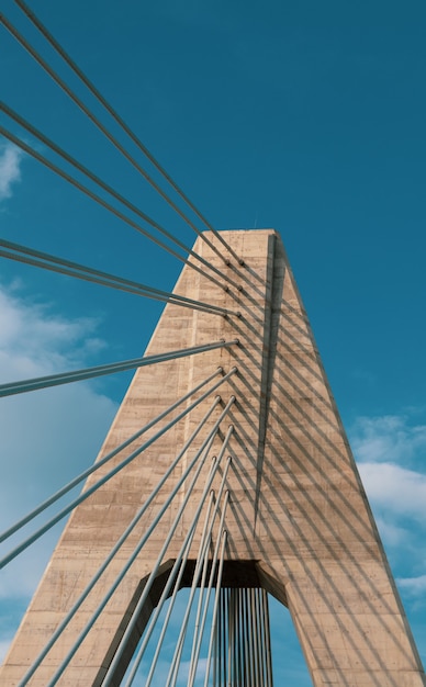 Free photo vertical shot of a bridge under a cloudy blue sky