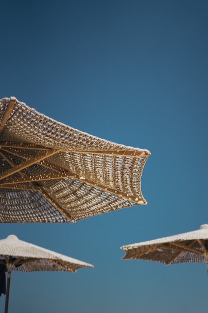 Free photo vertical shot of brown wooden parasols