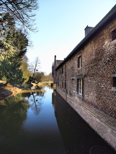 Free photo vertical shot of a building surrounded by water and trees