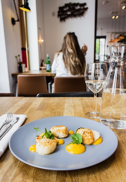 Free photo vertical shot of chicken and shrimps with special sauce on a round blue plate