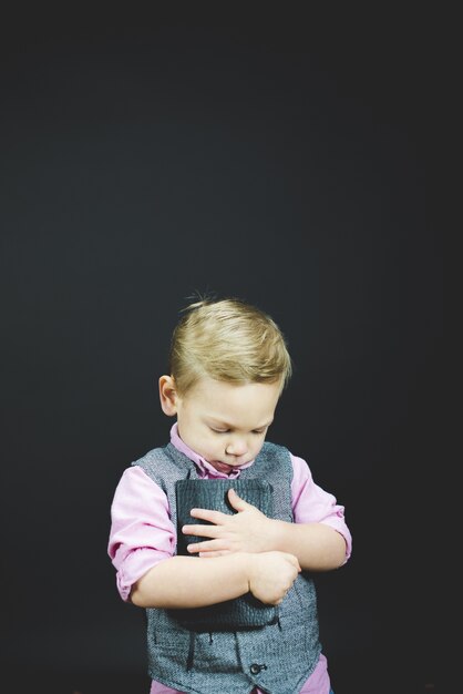 Vertical shot of a child holding the bible against his chest