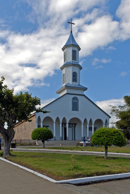 Vertical shot of a church with a blue cloudy sky in the background