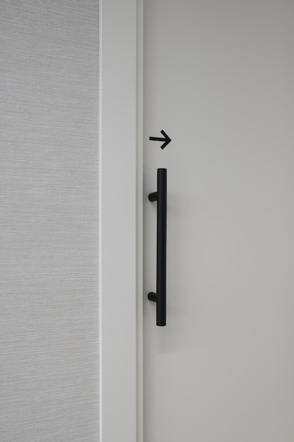 Free Photo vertical shot of a closed white door with a black arrow showing to the right