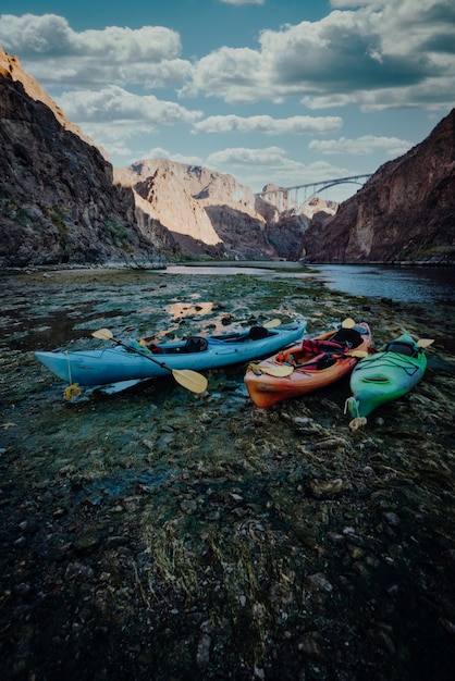 Free photo vertical shot of colorful kayak boats on the shore of the lake in the mountains