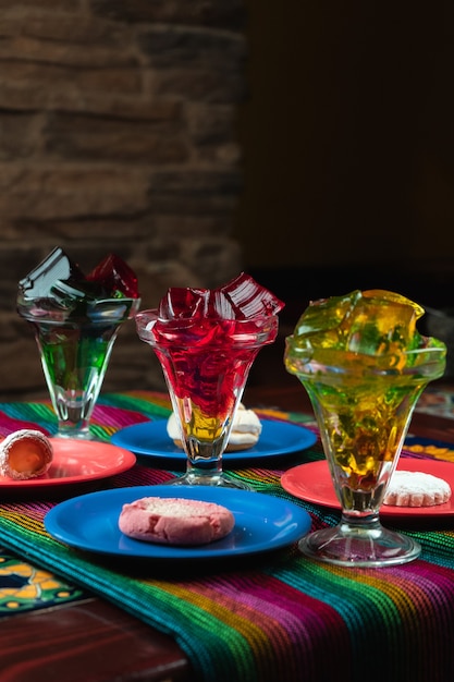 Vertical shot of colorful sweet jelly desserts next to cookie plates