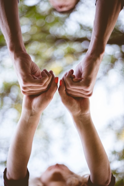 A vertical shot of a couple holding hands with a blurred background