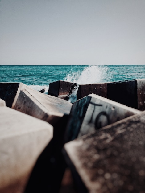 Free photo vertical shot of cubical rubbles and trash in the body of water in the ocean