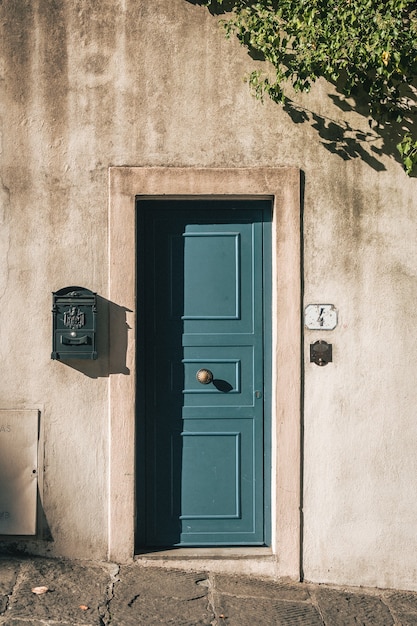 Free photo vertical shot of a cute blue door on a stone building