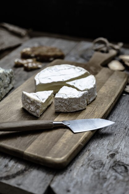 Vertical shot of delicious brie cheese on a wooden deck