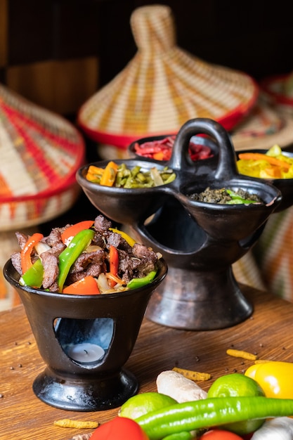 Free photo vertical shot of delicious ethiopian food with fresh vegetables on a wooden table