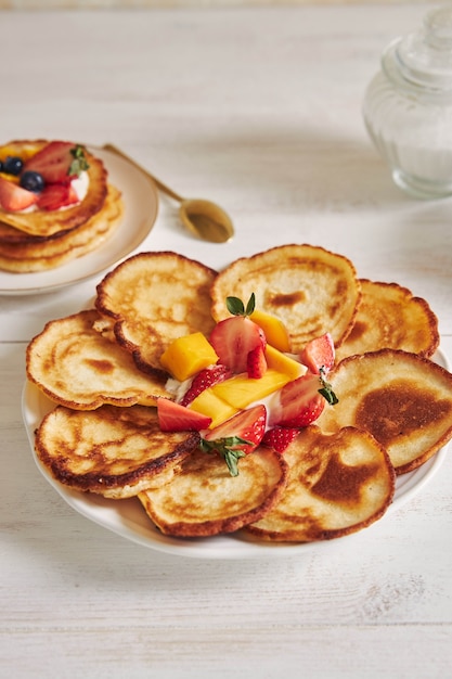 Vertical shot of delicious pancakes with fruits in the middle