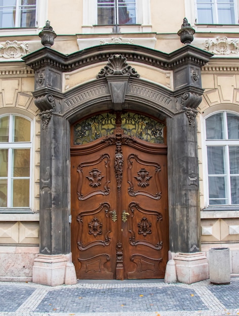 Vertical shot of the doors of a house surrounded by windows