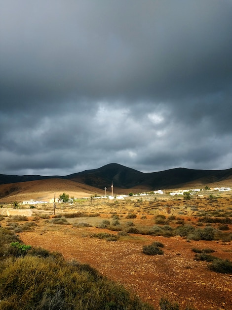 Free photo vertical shot of dry valley and hills in shadows before the stormy weather in fuerteventura, spain