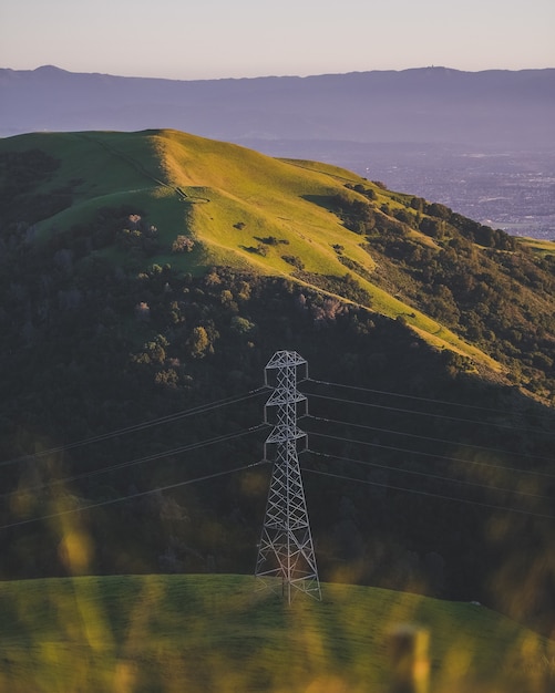 Free Photo vertical shot of an electric tower on a grassy mountain