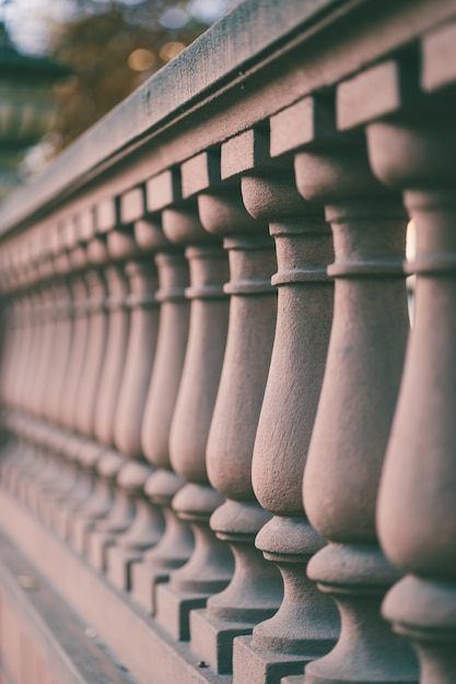 Free Photo vertical shot of fence columns of a bridge under the sunlight with a blurry background