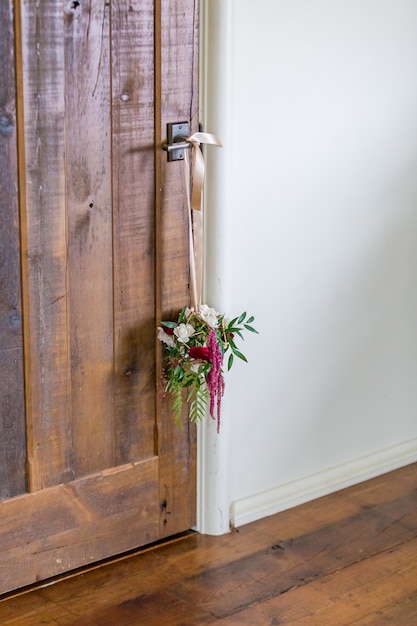 Free photo vertical shot of a flower decoration hanging from the door handle