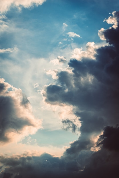 Vertical shot of the fluffy white clouds coming together in the sky