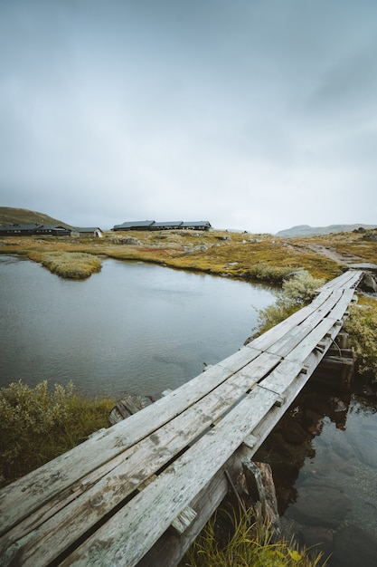 Free Photo vertical shot fo a wooden dock over a lake in finse, norway