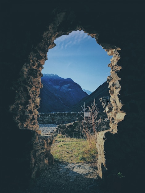 Free photo vertical shot from the inside of a cave with a mountain