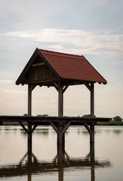 Vertical shot of a gazebo in a lake with reflection in the water