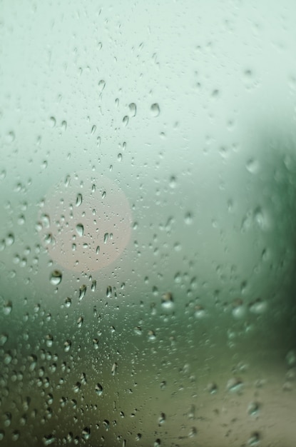 Vertical shot of a glass with raindrops forming the perfect autumn