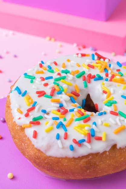 Vertical shot of a glazed donut topped with colorful sprinkles