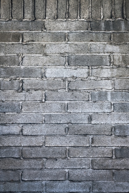 Free Photo vertical shot of a gray bricked wall with cement