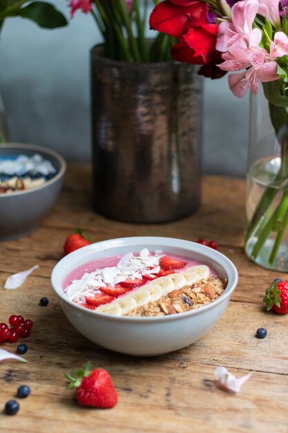 Vertical shot of a healthy smoothie bowl with fruits and granola