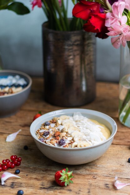 Vertical shot of a healthy smoothie bowl with fruits and granola