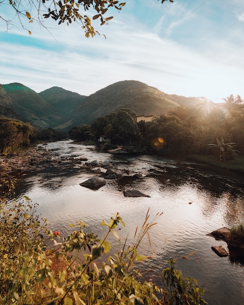 Free photo vertical shot of the hills by the beautiful river