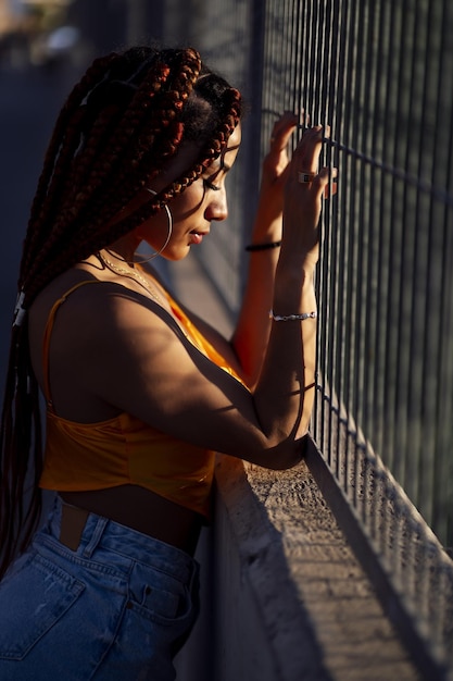 Vertical shot of a Hispanic woman with braids outdoors