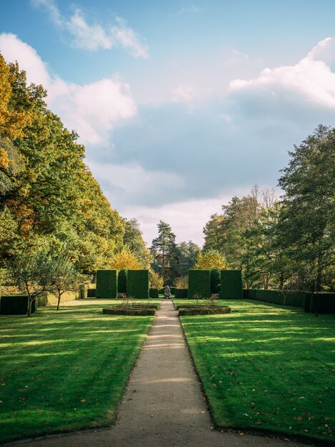 Vertical shot of the Hoetger Park covered in greenery under a cloudy sky in sunlight in Dortmund