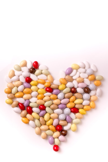 Vertical shot of jellybeans in heart shape and isolated on a white background