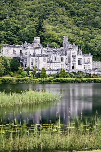 Free Photo vertical shot of kylemore abbey in ireland surrounded by greenery and a lake