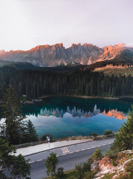 Vertical shot of the Lake Carezza surrounded by the Dolomites and greenery in South Tyrol Italy