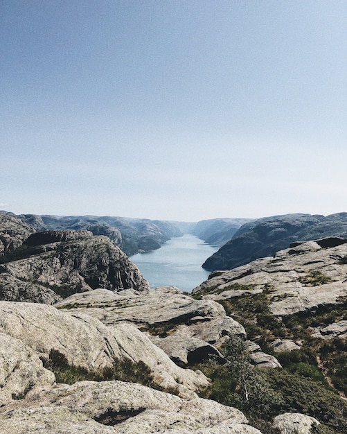 Free photo vertical shot of a lake surrounded by rock formations under the clear sky