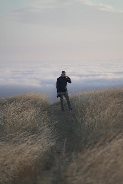 Free Photo vertical shot of a male looking at the camera on top of the mountain. tam in marin, ca