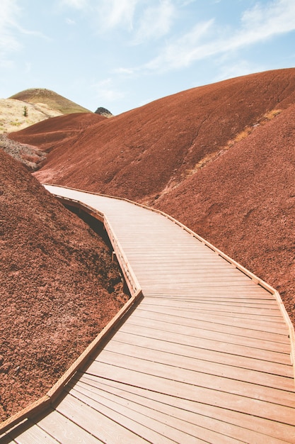 Free Photo vertical shot of a man-made wooden road in the hills of red sand