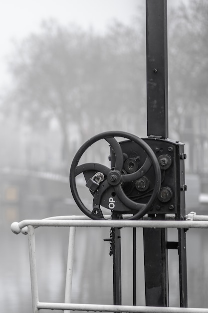 Vertical shot of a metal instrument with a small steering wheel