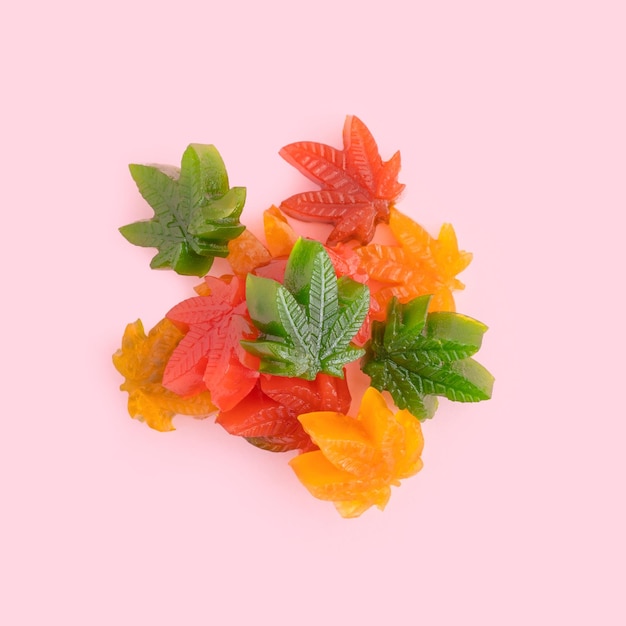 Vertical shot of multicolored leaf-shaped jelly candies with CBD oil