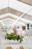 Free photo vertical shot of a nicely decorated table in a hall prepared for a ceremony