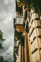 Free photo vertical shot of an old building facade with columns balconies and carved details