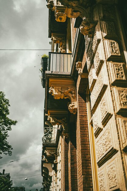 Vertical shot of an old building facade with columns balconies and carved details