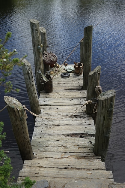 Free photo vertical shot of an old deck on a lake under the sunlight