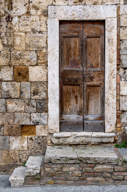 Free photo vertical shot of one of the san gimignano's historical building's entrance in tuscany, florence