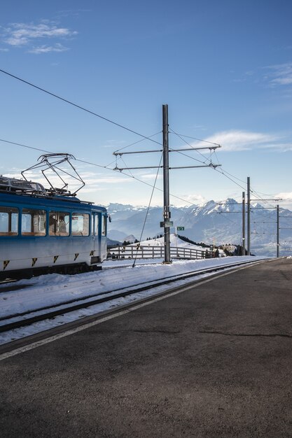 Vertical shot of an overhead line beside railway of an electric train under a clear blue sky