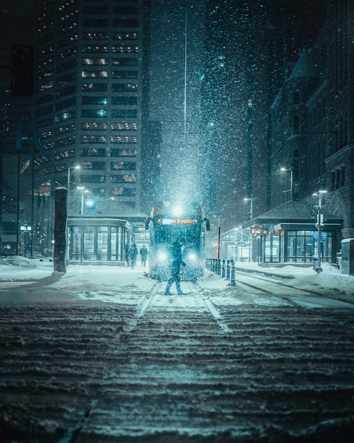 Free Photo vertical shot of a person in front of a train on a snowy road