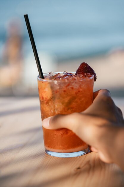 Vertical shot of a person holding a glass of refreshing