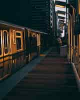 Free photo vertical shot of a railway station with the train during the sunrise