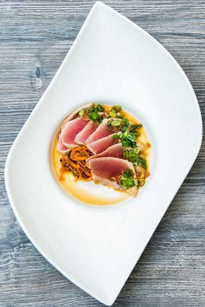 Free photo vertical shot of a raw mat with sliced vegetables on top in a white modern plate